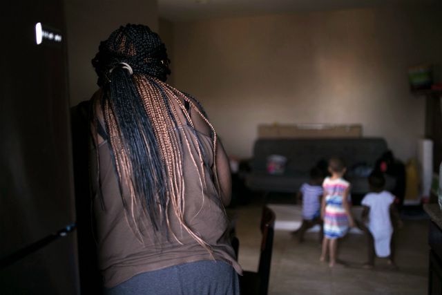 A mother and her children in their apartment that is filled with lead paint
